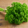Fresh parsley bunch beside a green juice on a sunlit counter, illustrating apigenin and bladder cancer research
