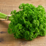 Fresh parsley bunch beside a green juice on a sunlit counter, illustrating apigenin and bladder cancer research